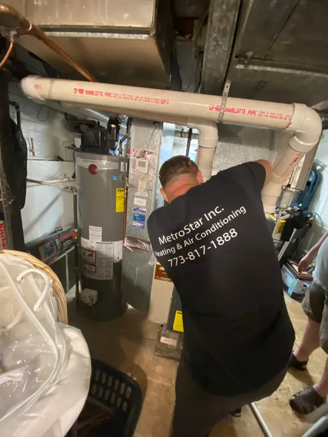 Peter repairing a furnace in a basement